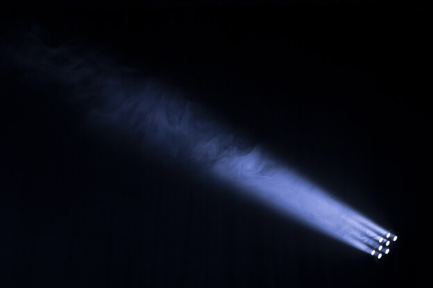 Black background and blue spotlight with smoke